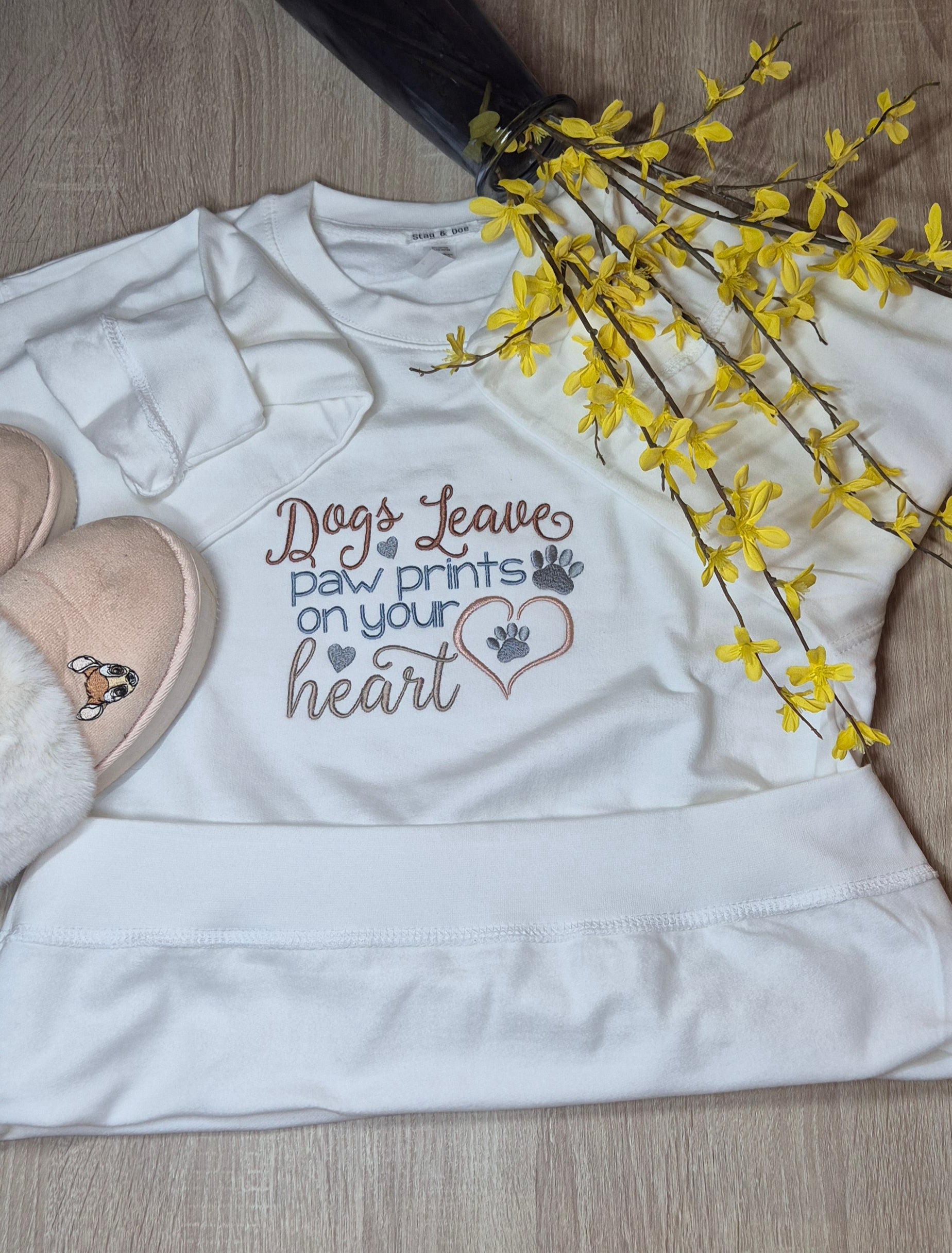 White Sweatshirt with slogan 'Dogs leave paw prints on your heart'.