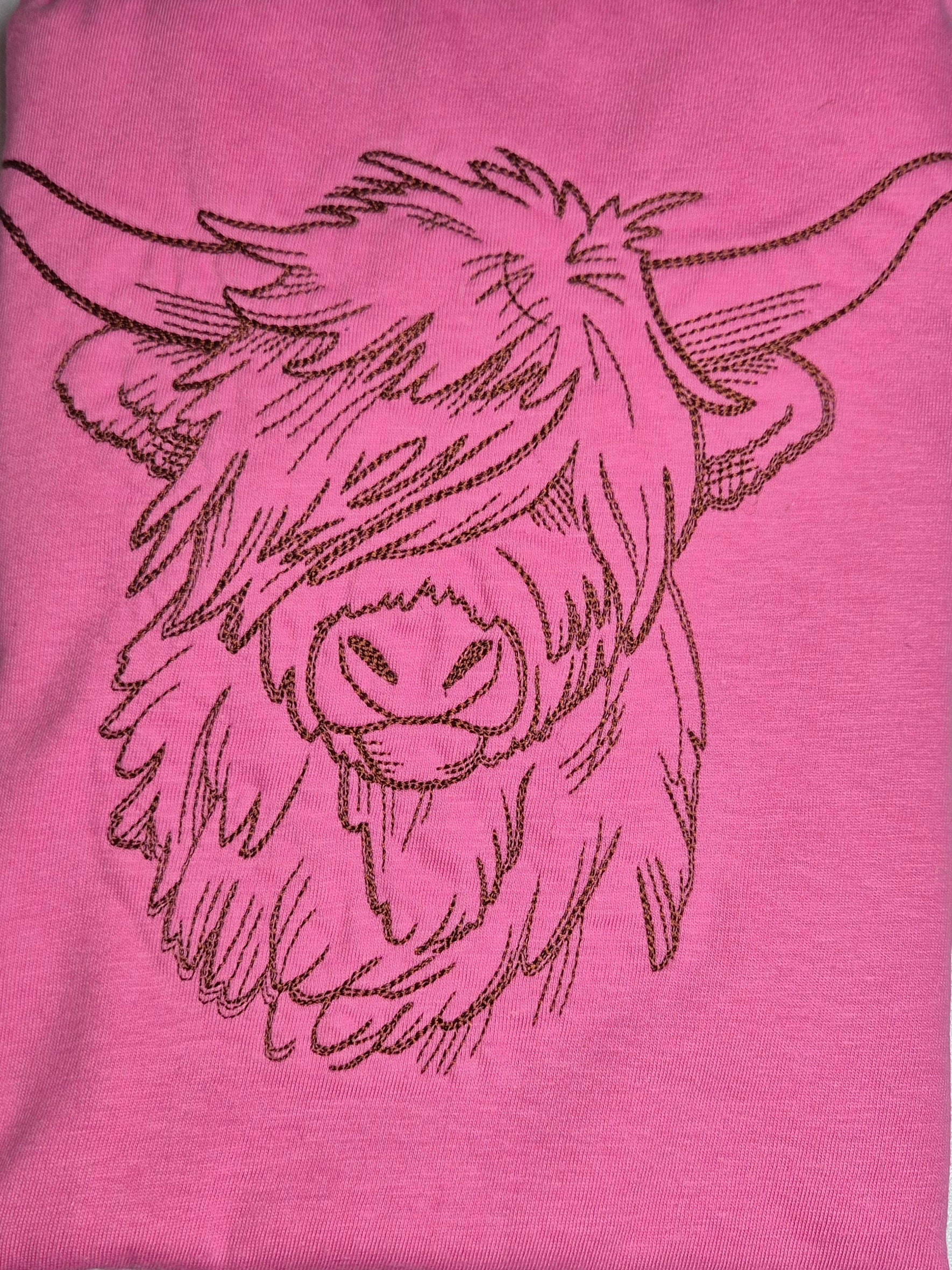 Pink t-shirt with a black embroidered design of a highland cow's head.